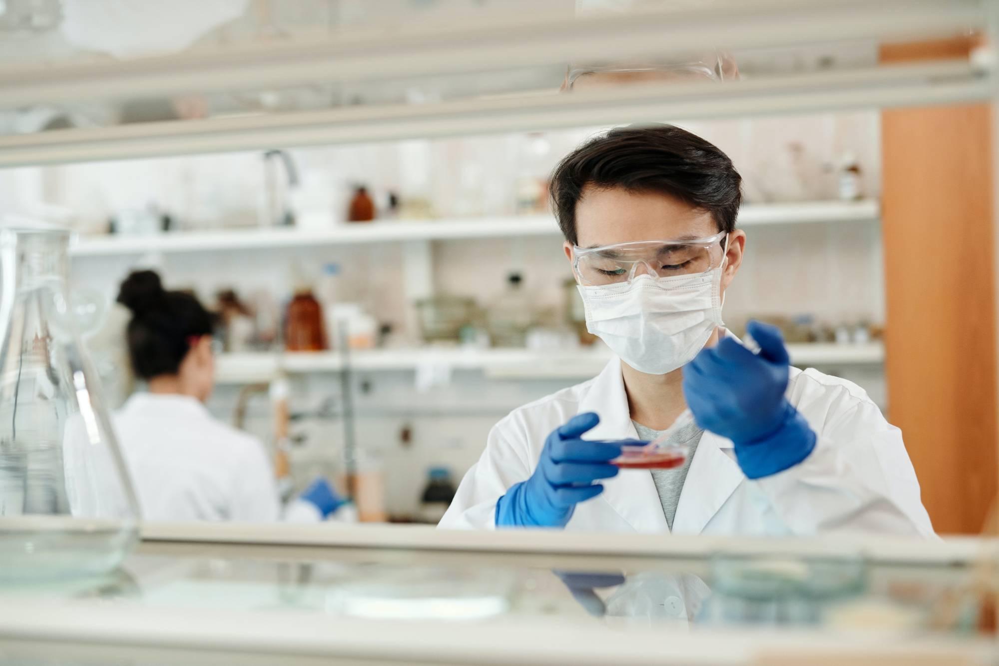 A scientist filling a needle with a liquid